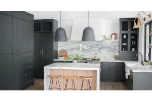 Angela Rose Home in her renovated kitchen with Slim Shaker Cabinet doors in Dream Dusk, marble counters, new appliances, and brass hardware.