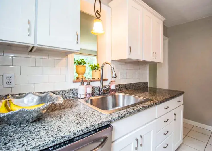 A photo of an updated kitchen with white shaker cabinet doors.