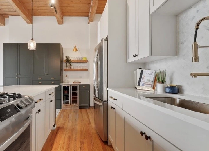 A kitchen with soft grey shaker cabinet doors with dream dusk shaker on an end wall, a wood paneled ceiling, and stainless steel appliances.